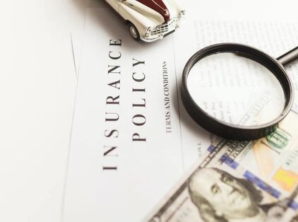 Northumberland_Hearing_Center_hearing_aid_insurance_policy_terms_and_conditions_apply_toy_car_magnifying_glass_hundred_dollar_bill_benjamin_franklin